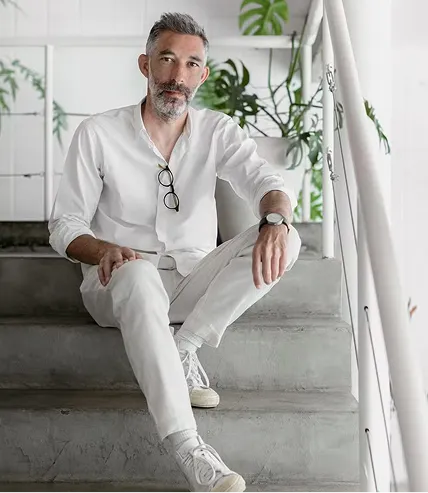 Greg Bousquet sentado em uma escada