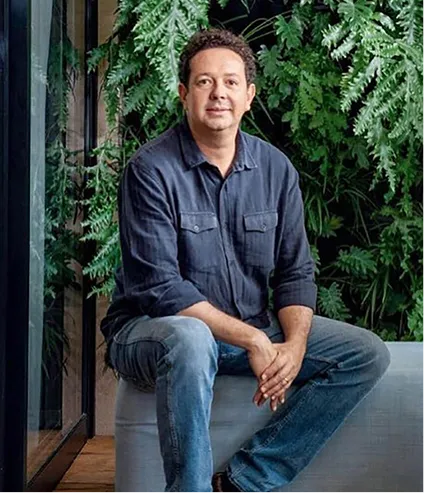 Rodrigo Oliveira sentado diante de um jardim